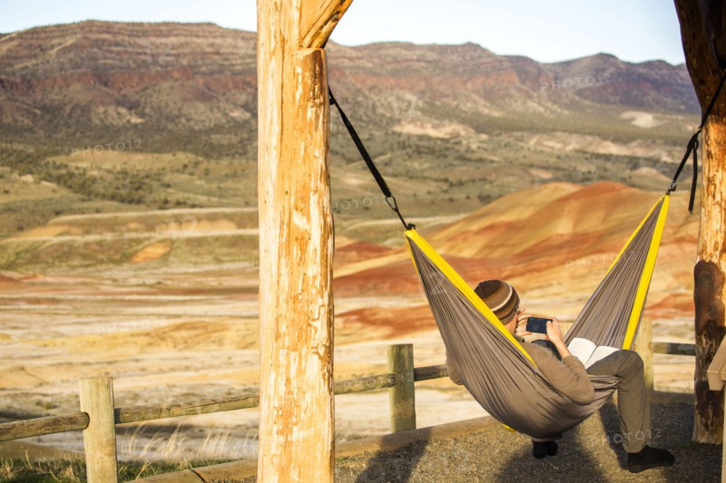 Caucasian man drinking coffee in hammock