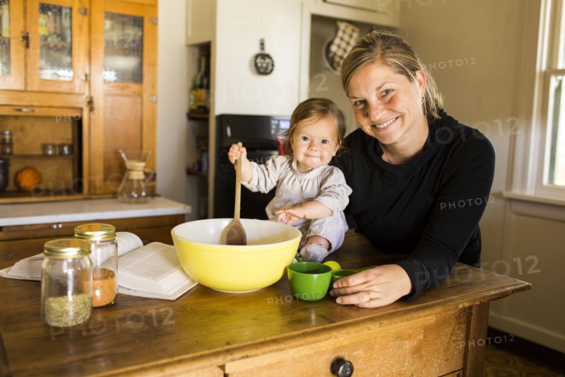 Caucasian mother and baby girl baking in kitchen