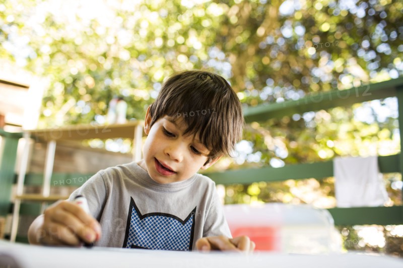 Mixed race boy coloring on porch
