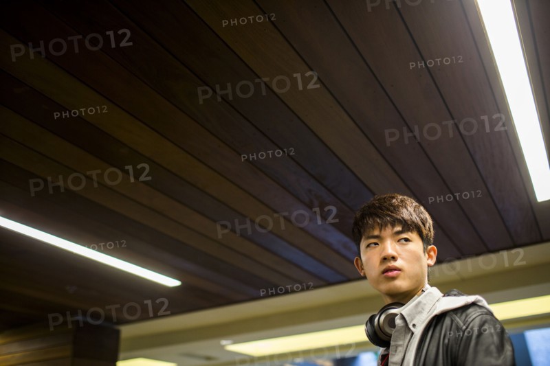 Asian man walking under wooden ceiling