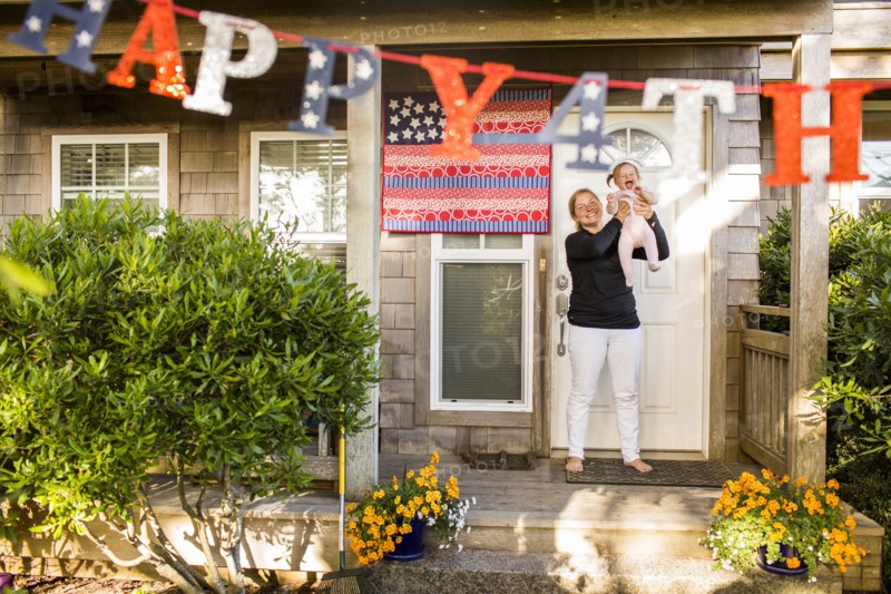 Caucasian mother and baby daughter celebrating 4th of July