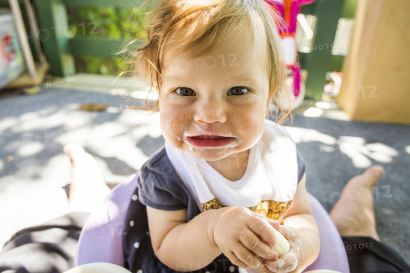 Caucasian baby girl eating on patio