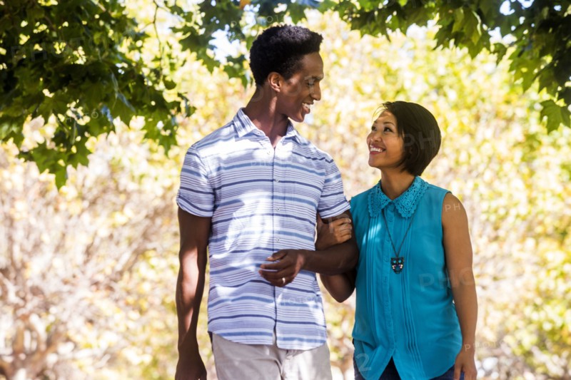 Couple walking arm-in-arm outdoors