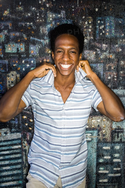Man lifting his collar by mural