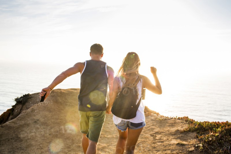 Caucasian couple walking on cliff