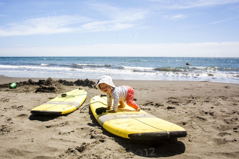 Caucasian baby crawling on surfboard