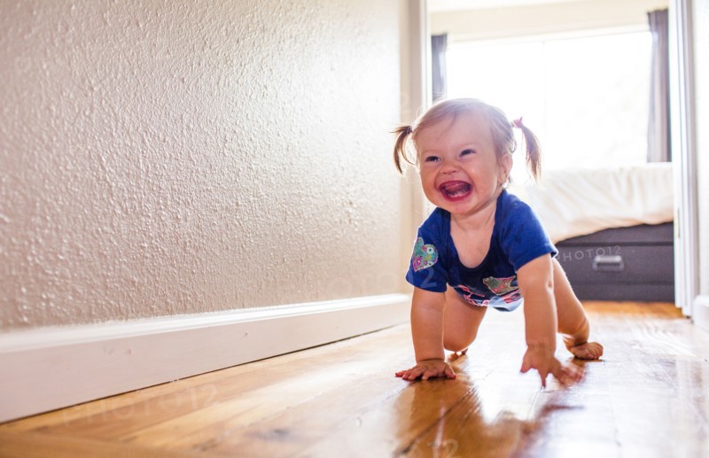 Caucasian baby girl crawling in hallway