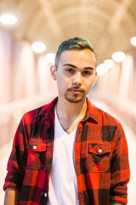 Serious Hispanic man wearing flannel shirt
