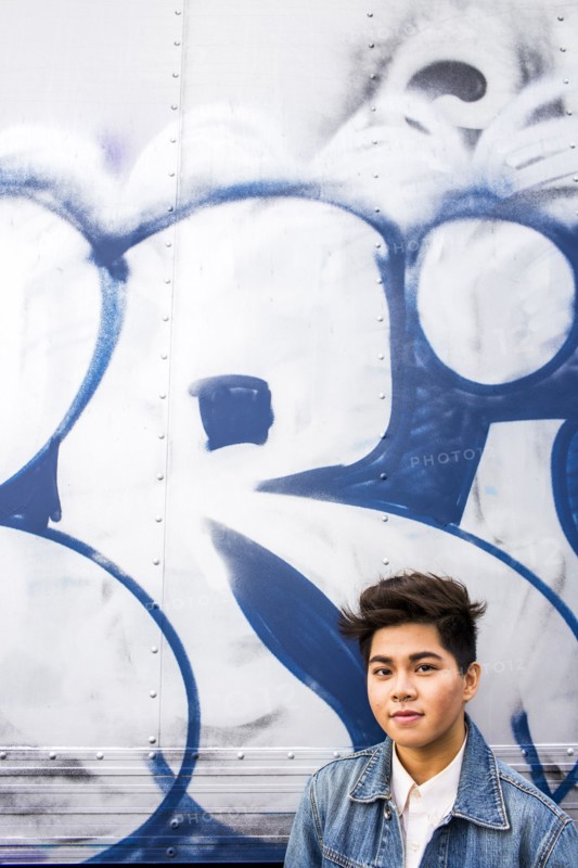 Asian woman standing at graffiti wall