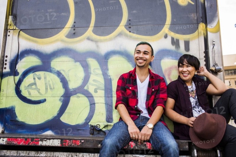 Couple sitting on graffiti truck