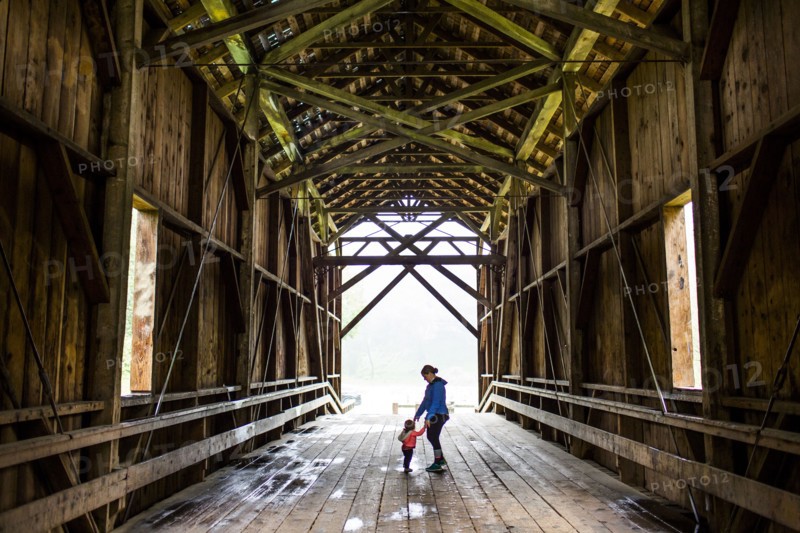 Caucasian mother and baby daughter on covered bridge