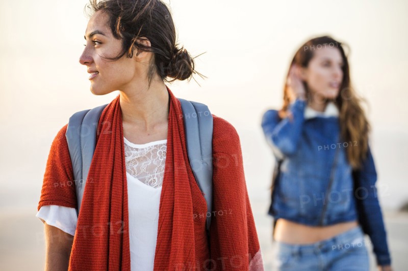Mixed race women walking on beach