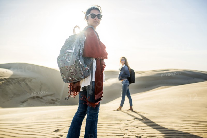 Mixed race women standing on sand dunes