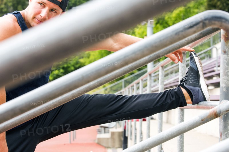 Caucasian man stretching leg at running track
