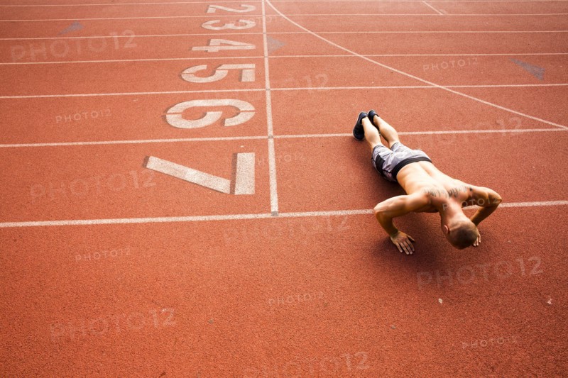 Caucasian man doing push-ups on running track