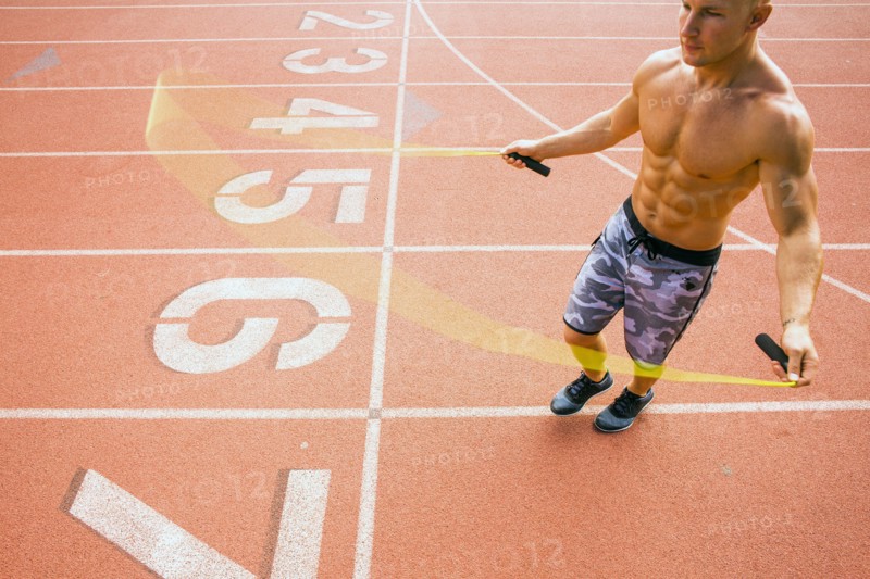 Caucasian man jumping rope on running track