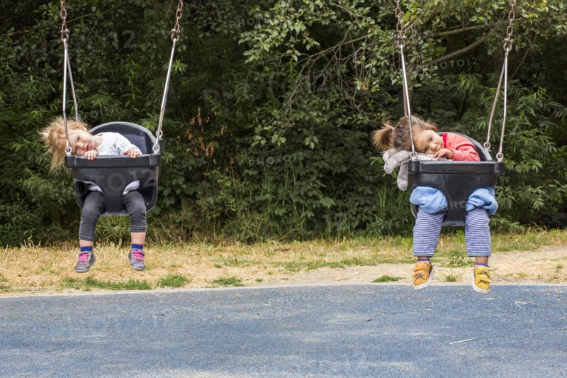 Girls sitting in still swings