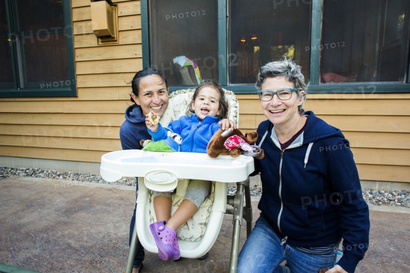 Mothers posing with daughter in high chair