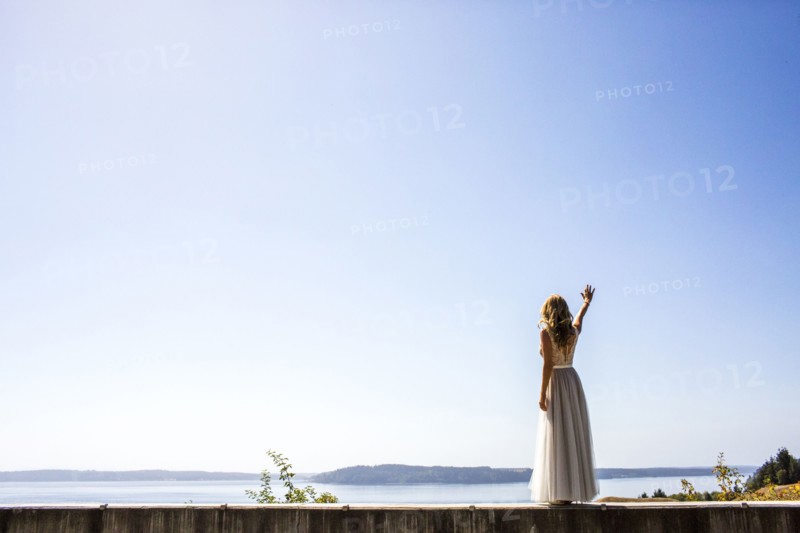 Caucasian bride waving near river