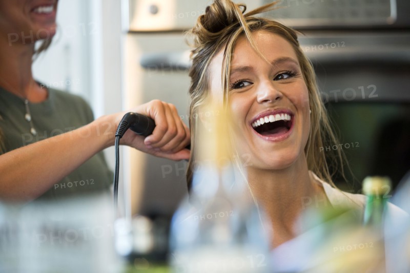 Caucasian woman smiling with hair stylist