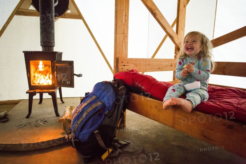 Caucasian girl laughing on bed in yurt