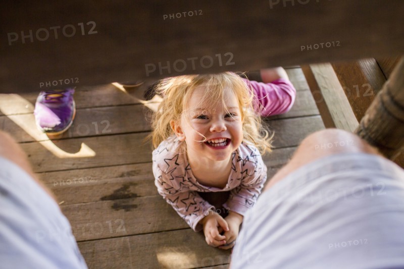 Portrait of smiling Caucasian girl laying underneath table