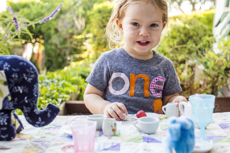 Caucasian girl playing with tea set