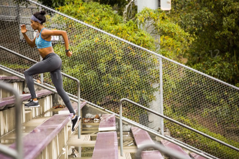 Black woman running on bleachers