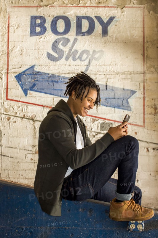 Androgynous Mixed Race woman texting on cell phone
