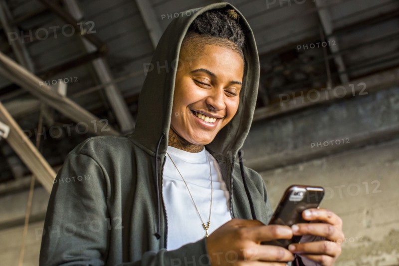 Androgynous Mixed Race woman texting on cell phone