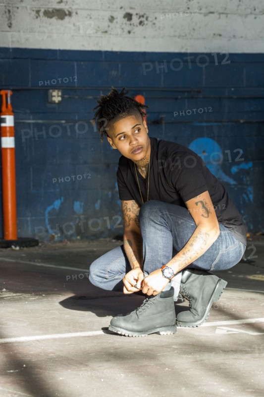 Androgynous Mixed Race woman tying shoelace