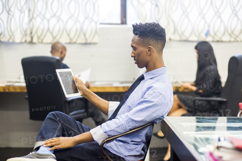 Black man using digital tablet in office