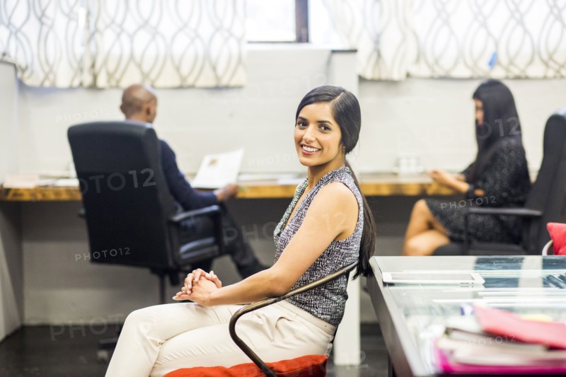 Portrait of smiling Asian woman sitting in office