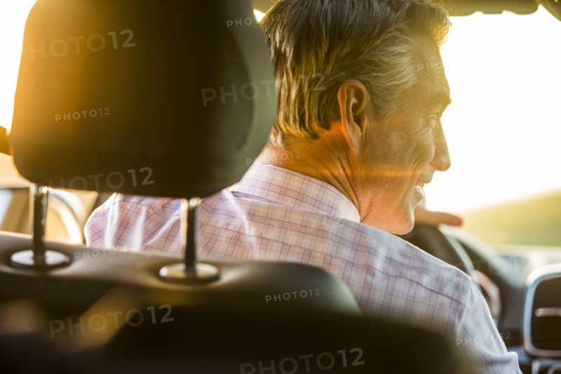 Smiling Caucasian man driving car