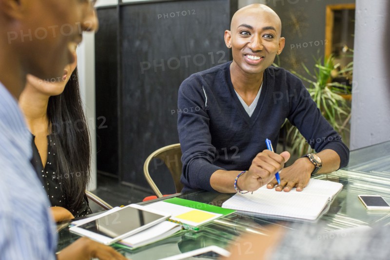 Smiling man with notebook in meeting