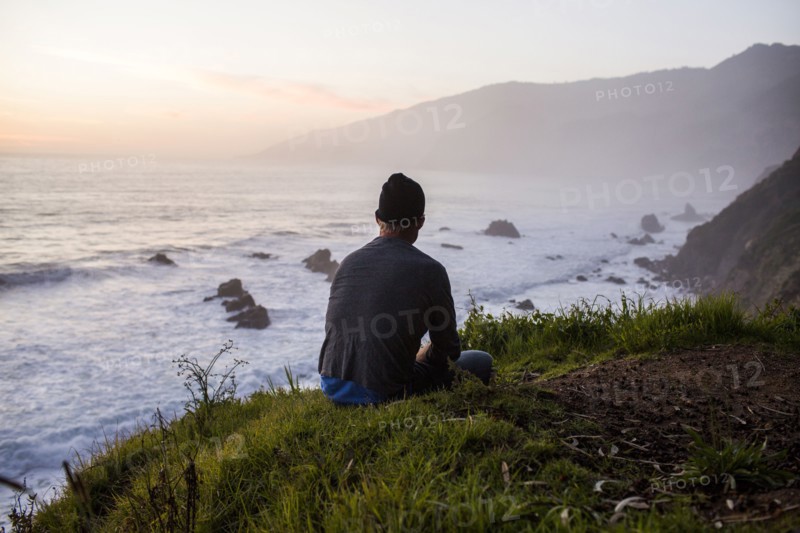 Caucasian man admiring ocean waves at sunset
