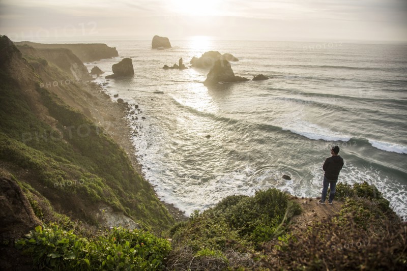 Caucasian man admiring scenic view of ocean sunset