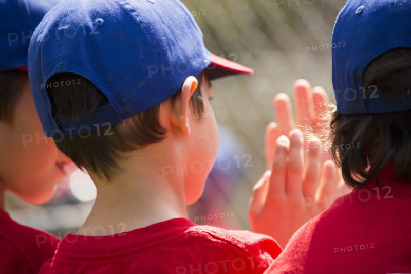 Mixed Race boys playing baseball high-fiving