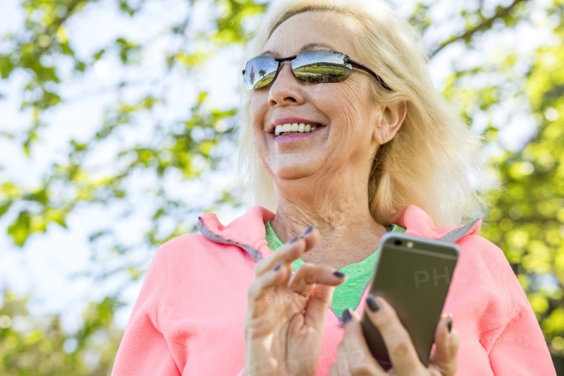 Older Caucasian woman texting on cell phone outdoors