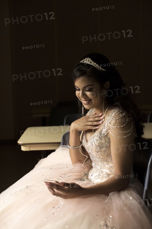 Smiling Hispanic girl listening to cell phone with earbuds