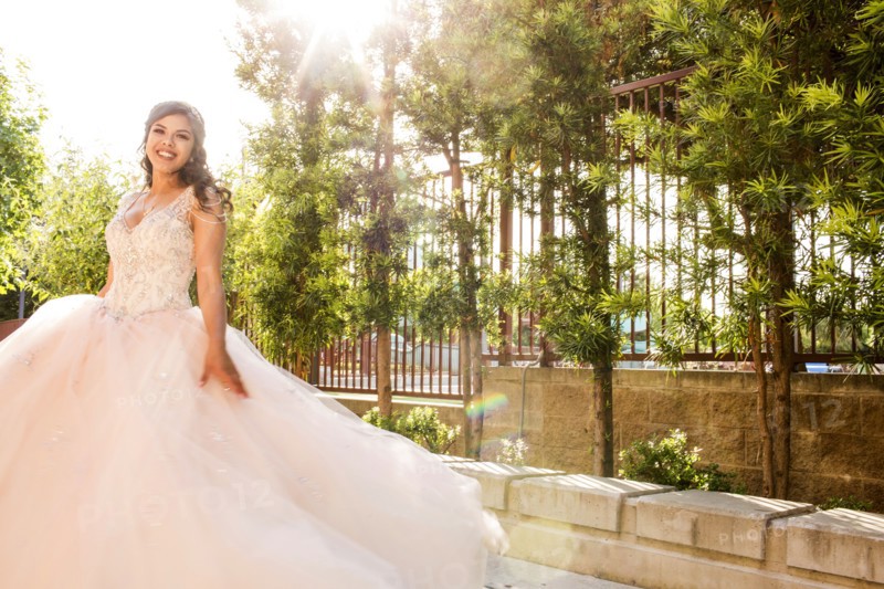 Smiling Hispanic girls wearing gown in park