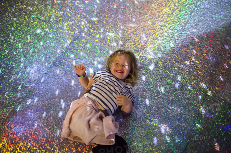 Caucasian girl laying on floor under disco ball