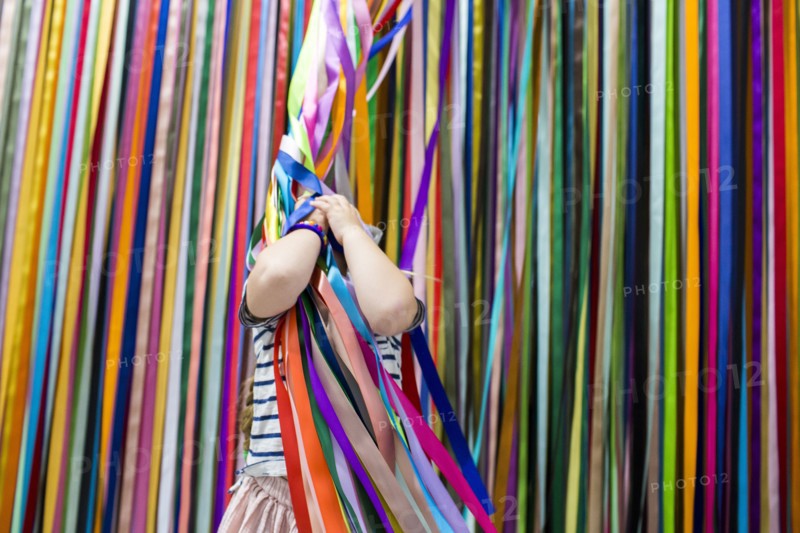 Caucasian girl playing with colorful hanging streamers