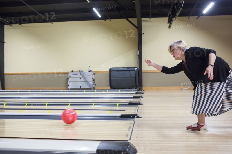 Caucasian woman releasing bowling ball in lane