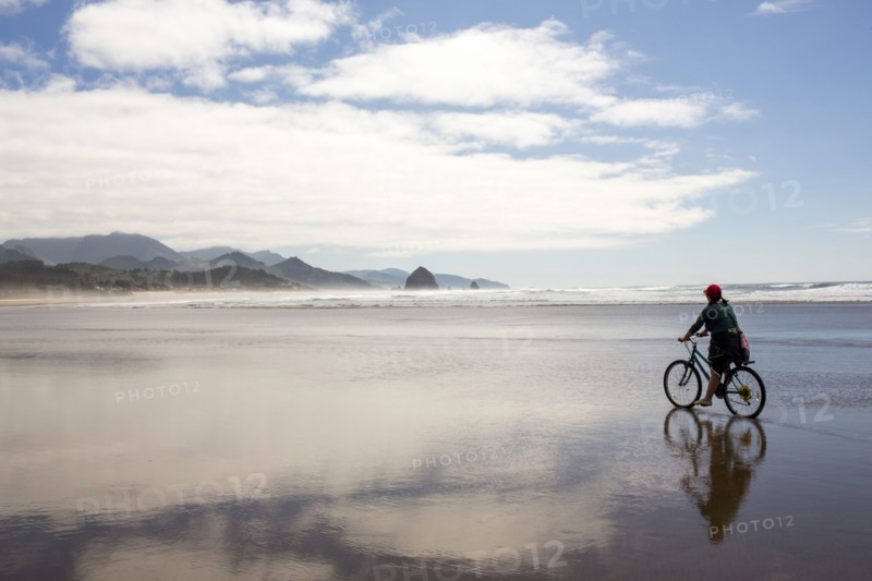 Caucasian woman riding bicycle on beach