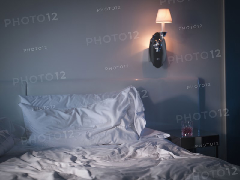 Messy sheets on bed in bedroom