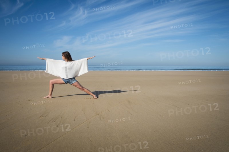 Caucasian woman practicing yoga on beach