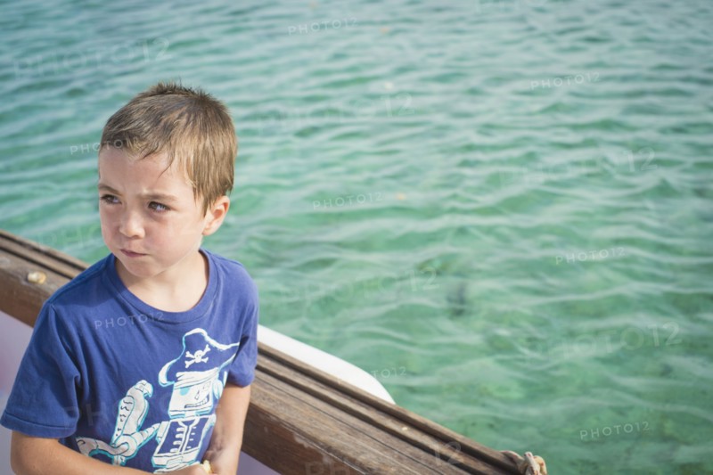 Caucasian boy on boat in water