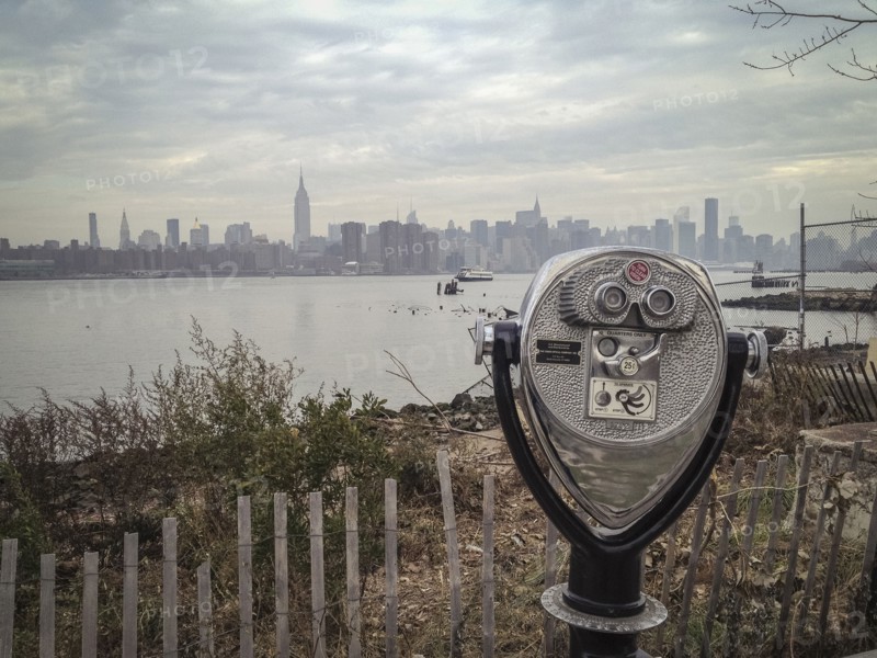 Coin-operated binoculars viewing city skyline on urban waterfront