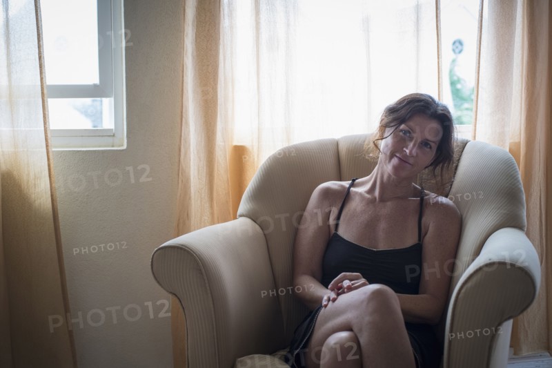 Caucasian woman sitting in armchair in living room